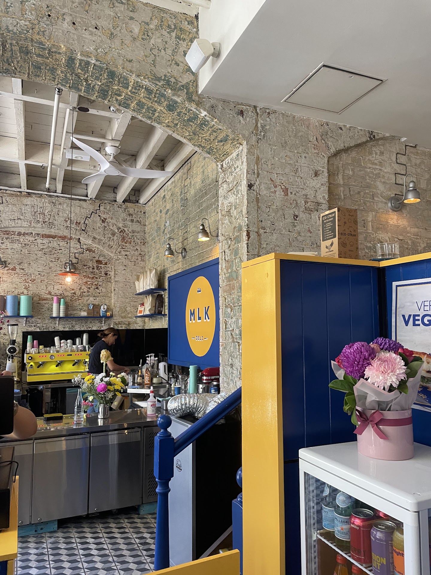 Interior of MLK Deli with brick walls and blue and yellow counter
